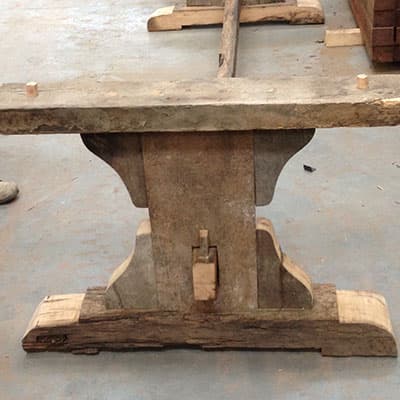 Detail van het eikenhouten kruisonderstel van de tafel