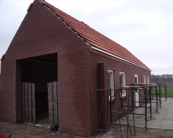 Bakstenen garage in aanbouw met een open gevelopening