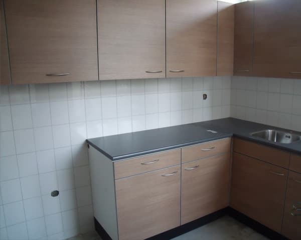 Afgewerkte keuken met houten fronten en een donker werkblad