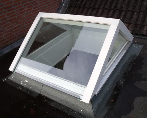 Openstaande lichtstraat met wit kozijn op een plat dak