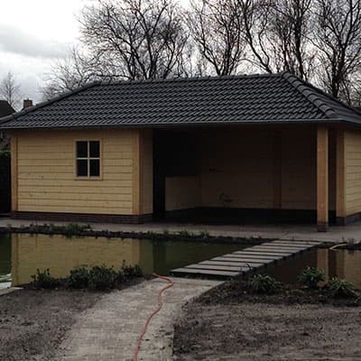 Tuinhuis met overkapping aan de rand van een vijver