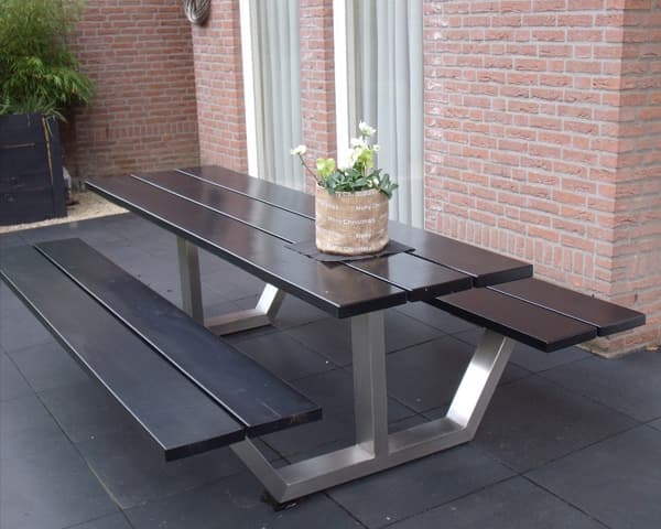 Donkere tuintafel met twee banken op stalen poten, op een terras