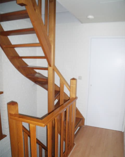 Eikenhouten trap met open treden en een houten balustrade