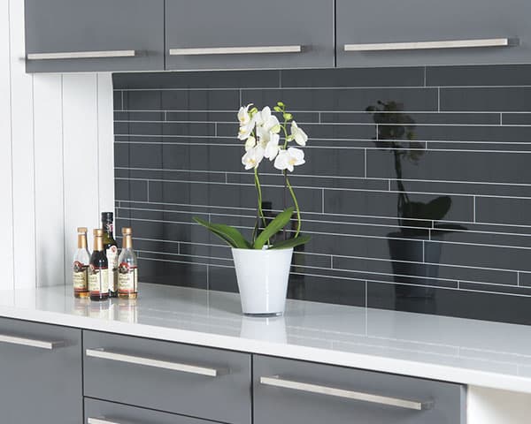 Keuken met een grijze achterwand in natuursteenlook en grijze fronten
